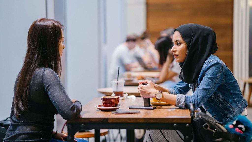 two young women having a conversation in coffee shop